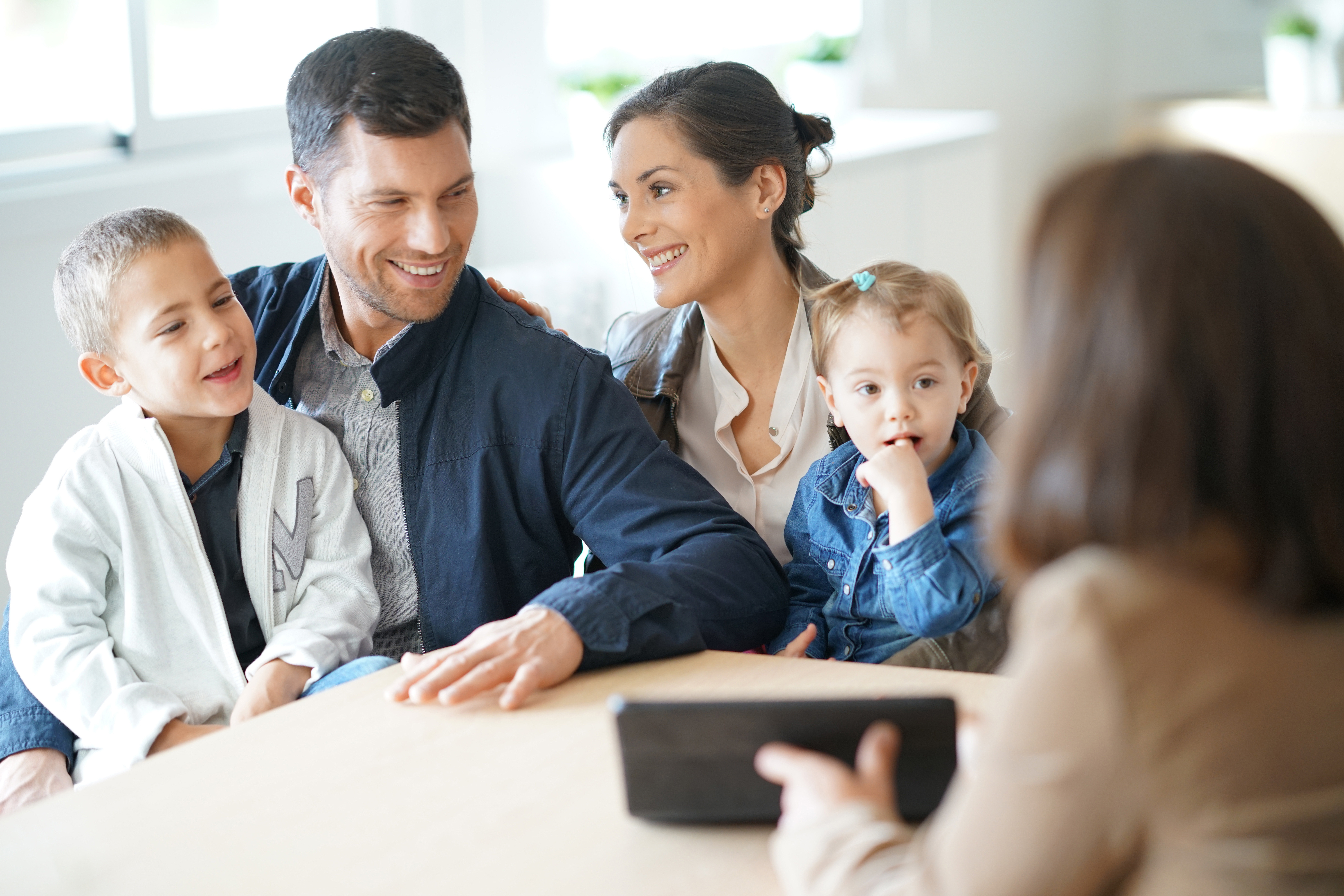 Young family reading from tablet 