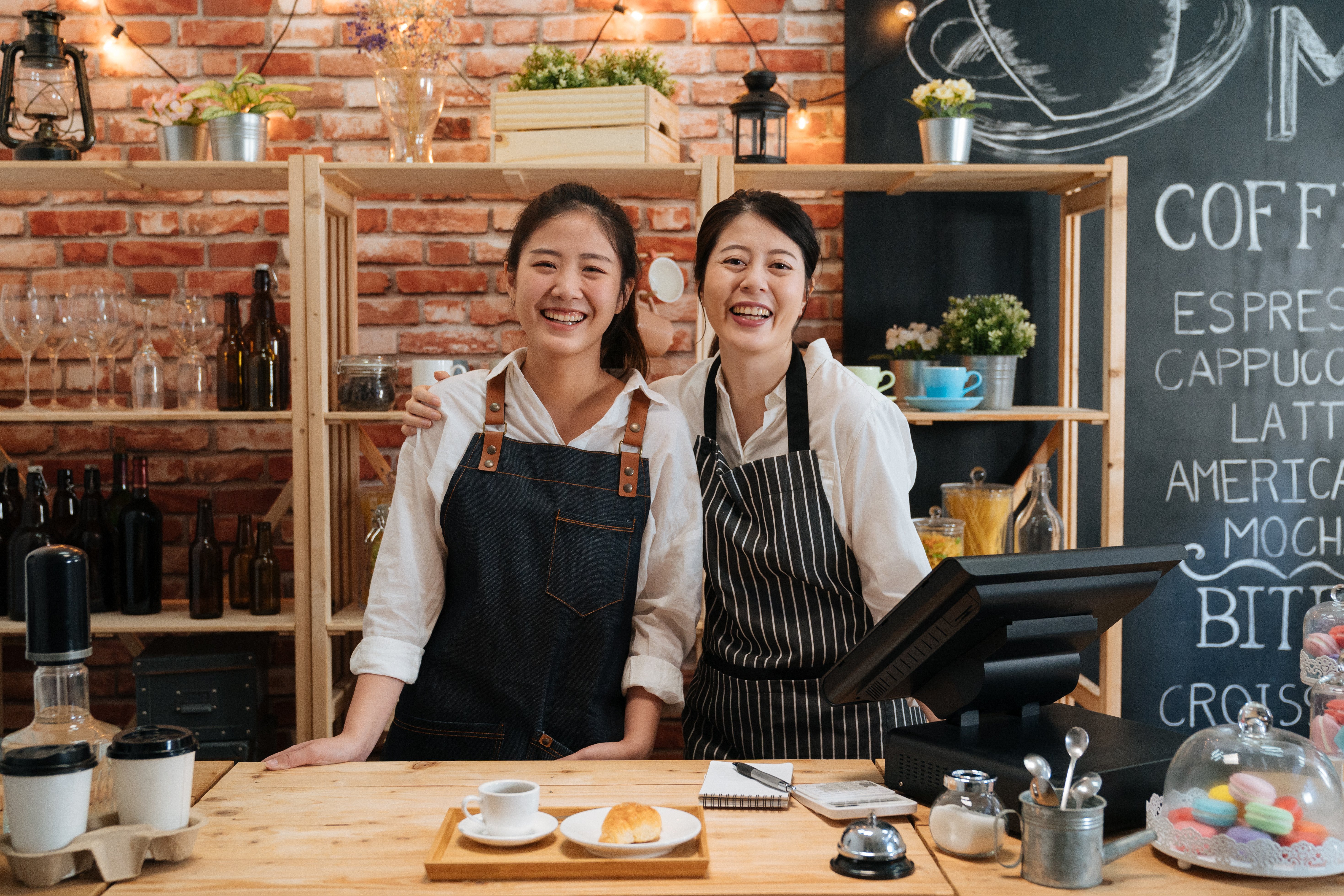 1 older woman of color with her arm around her younger employee