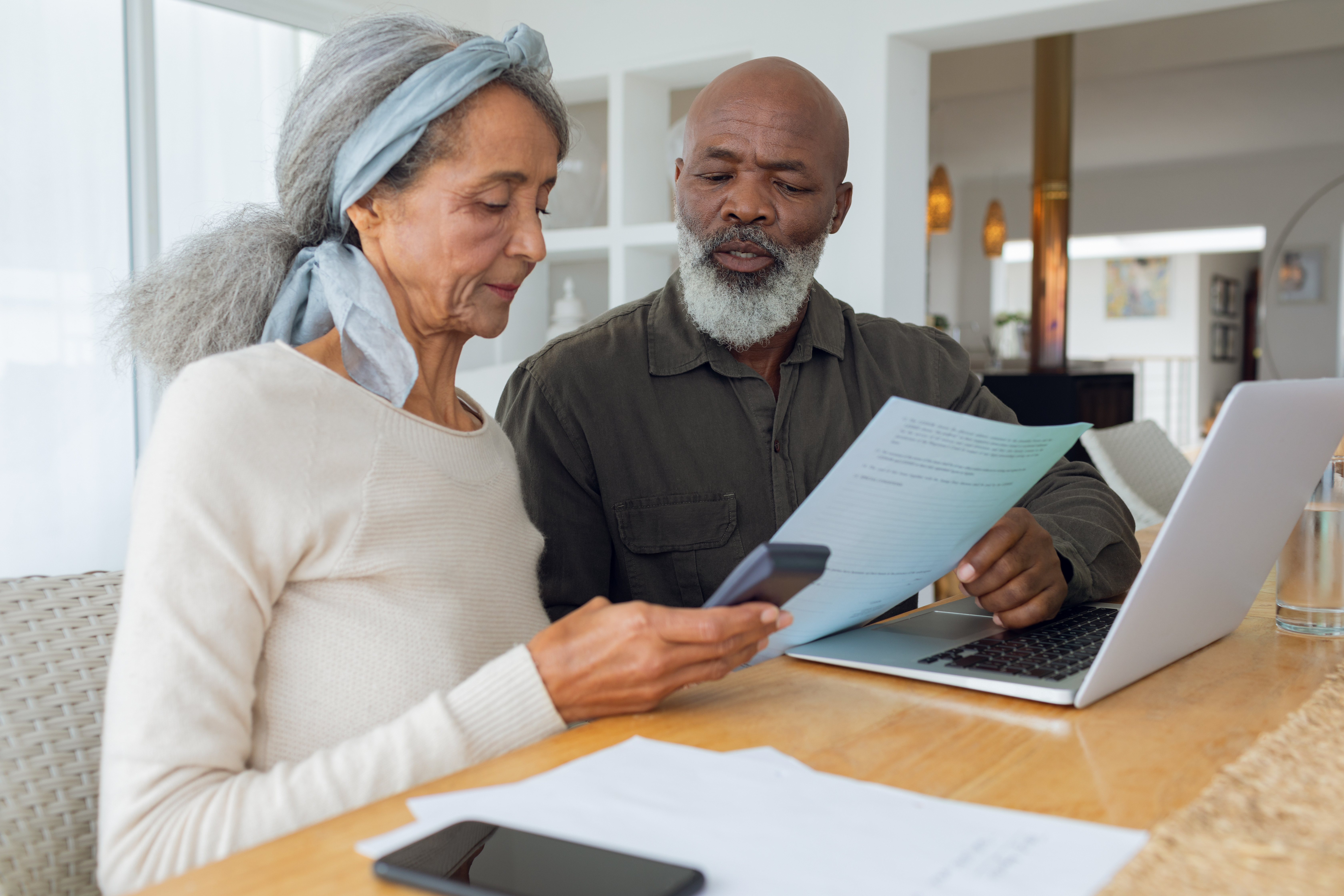 Black man and woman using a calculator to review insurance costs 