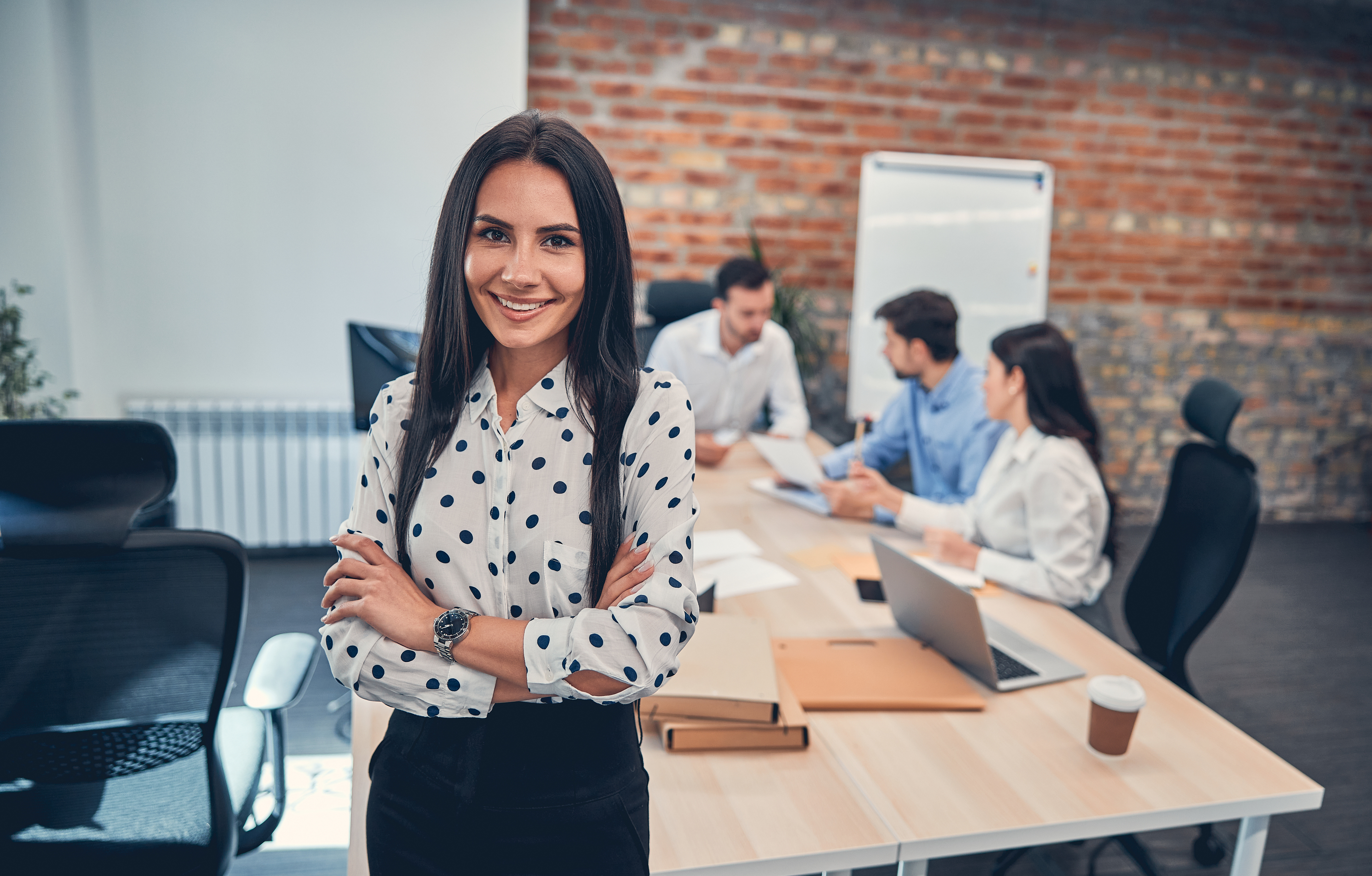 Young professional woman smiling in front of her team 