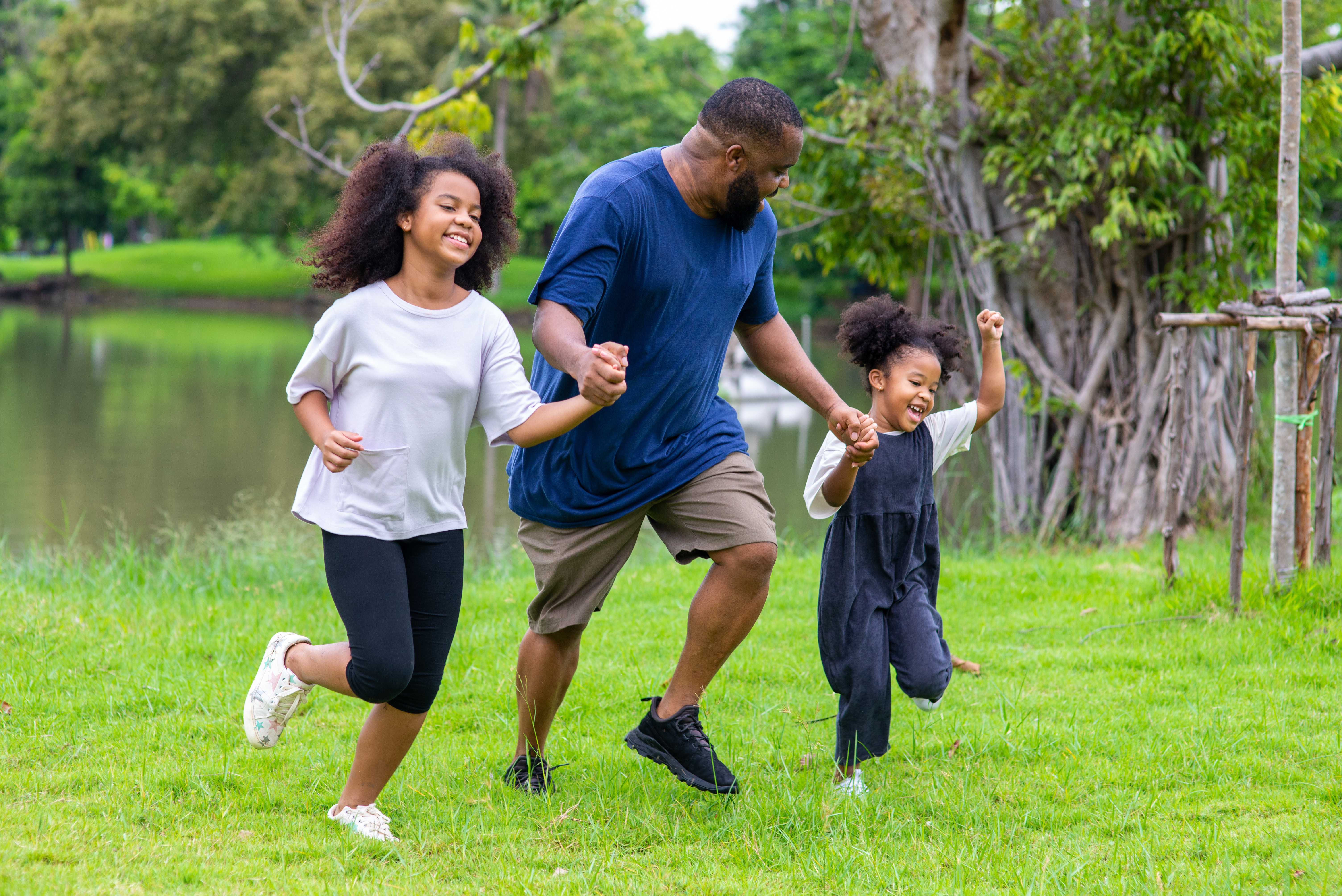 Father running by pond with this two kids 