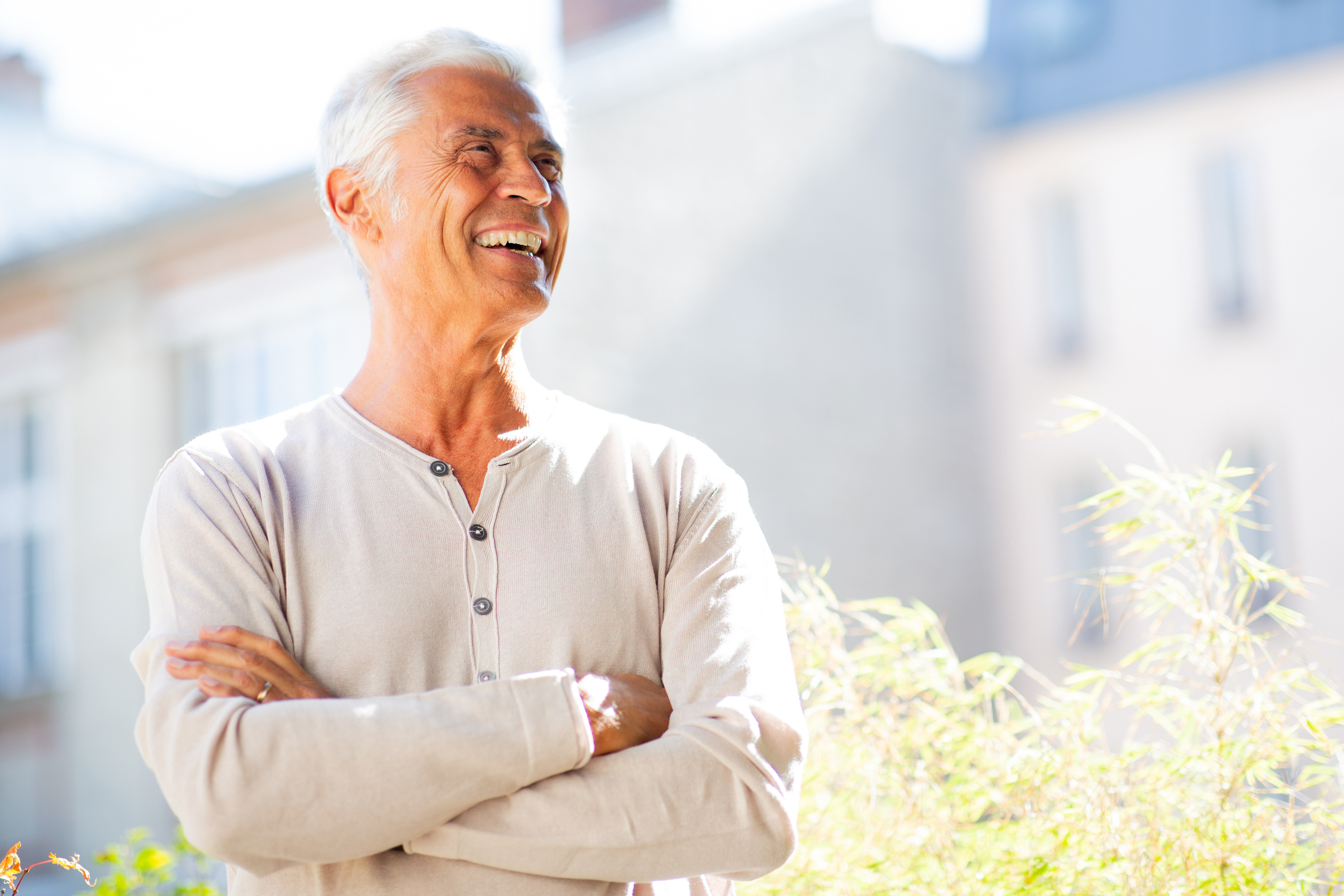 Senior crossing his arms in a field and smiling