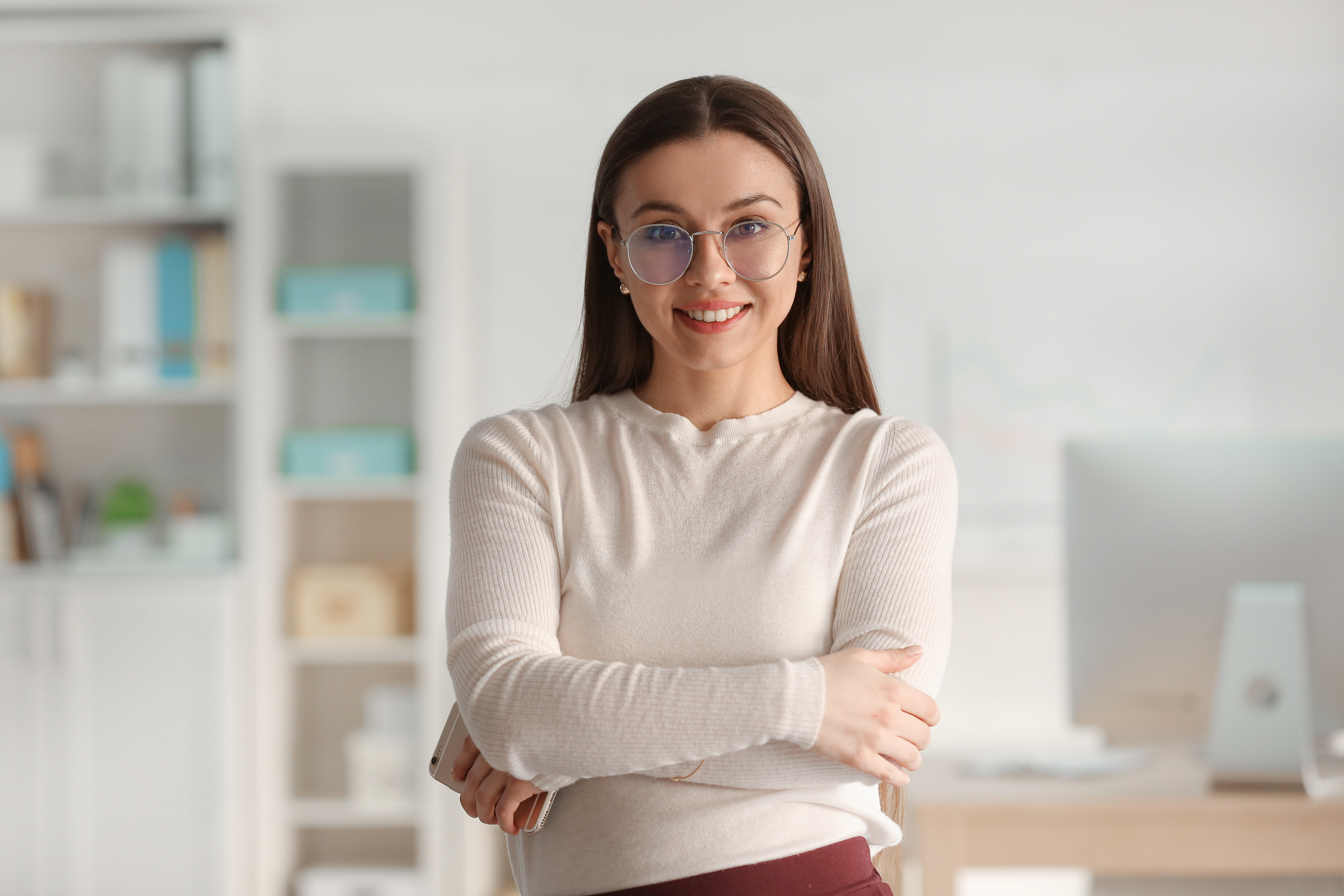 A young woman crossing her arms and smiling