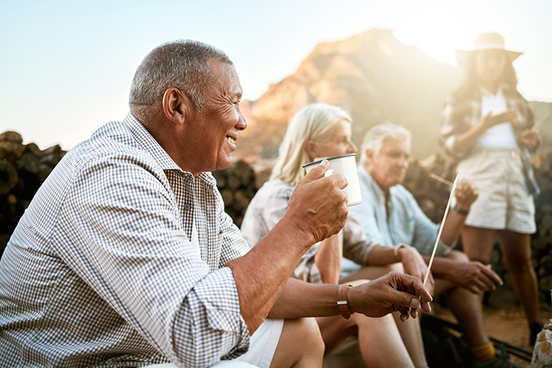 Retiree man outside smiling around campsite