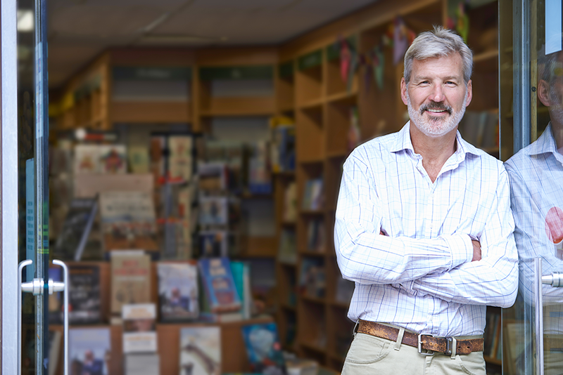 Man in Stripped Shirt leaning in business doorway